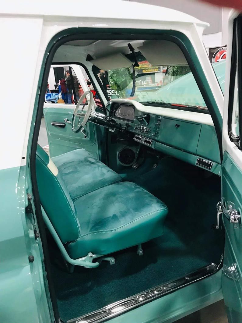 The inside of a green and white truck with the door open.