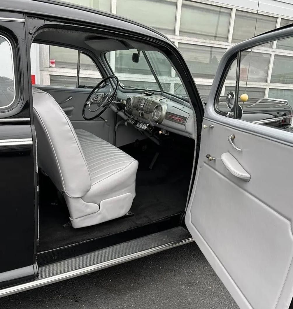 The inside of an old car with the door open