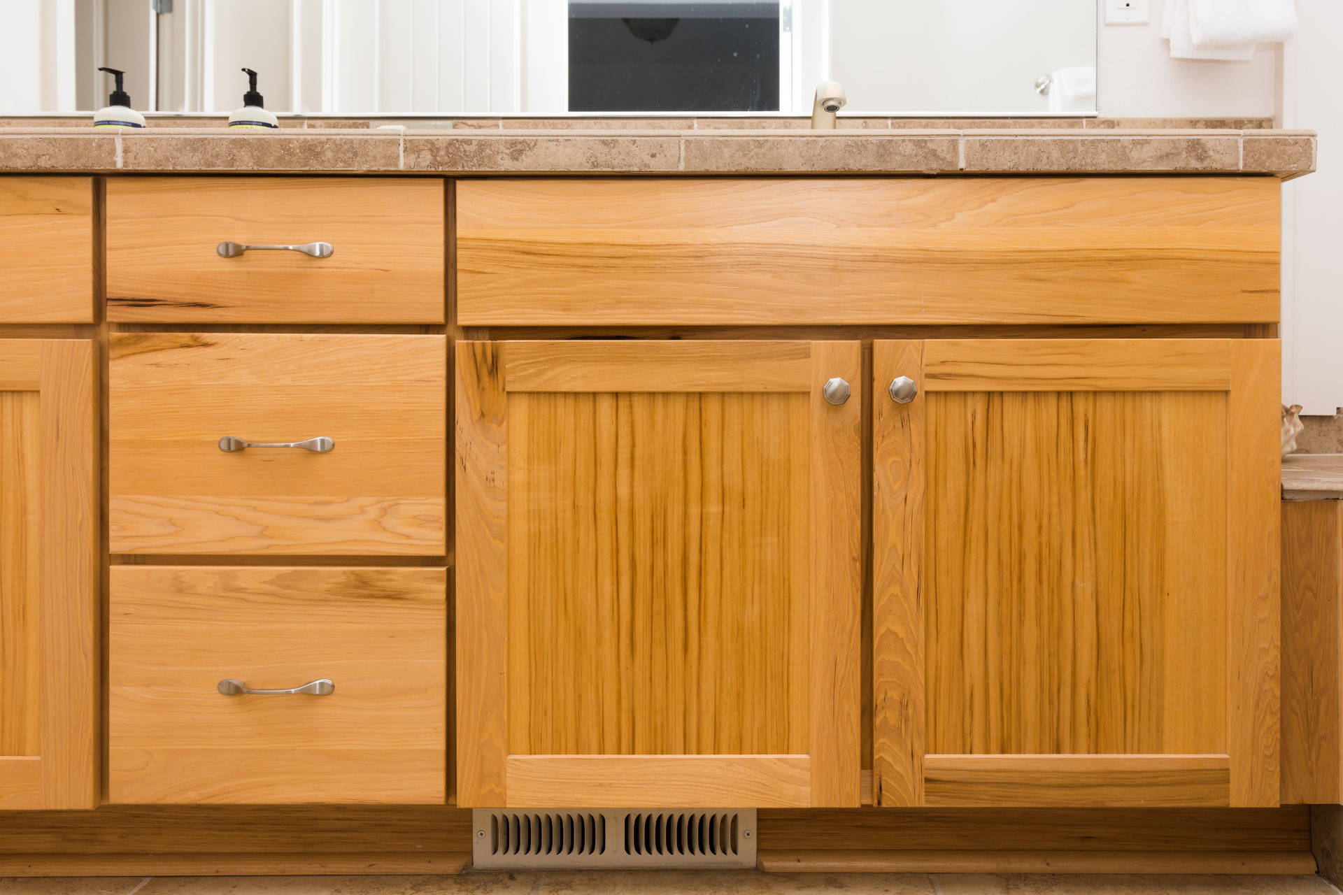 a bathroom vanity with wooden cabinets and drawers .