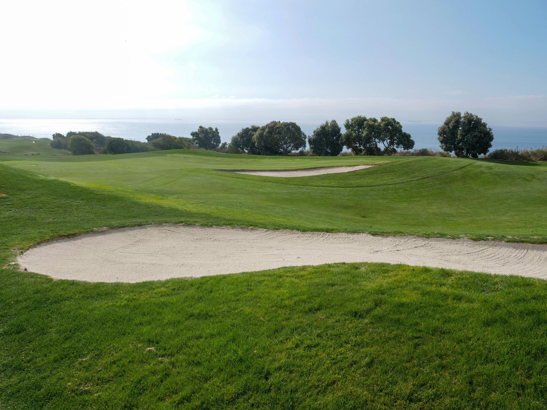 A golf course with a bunker in the middle of it