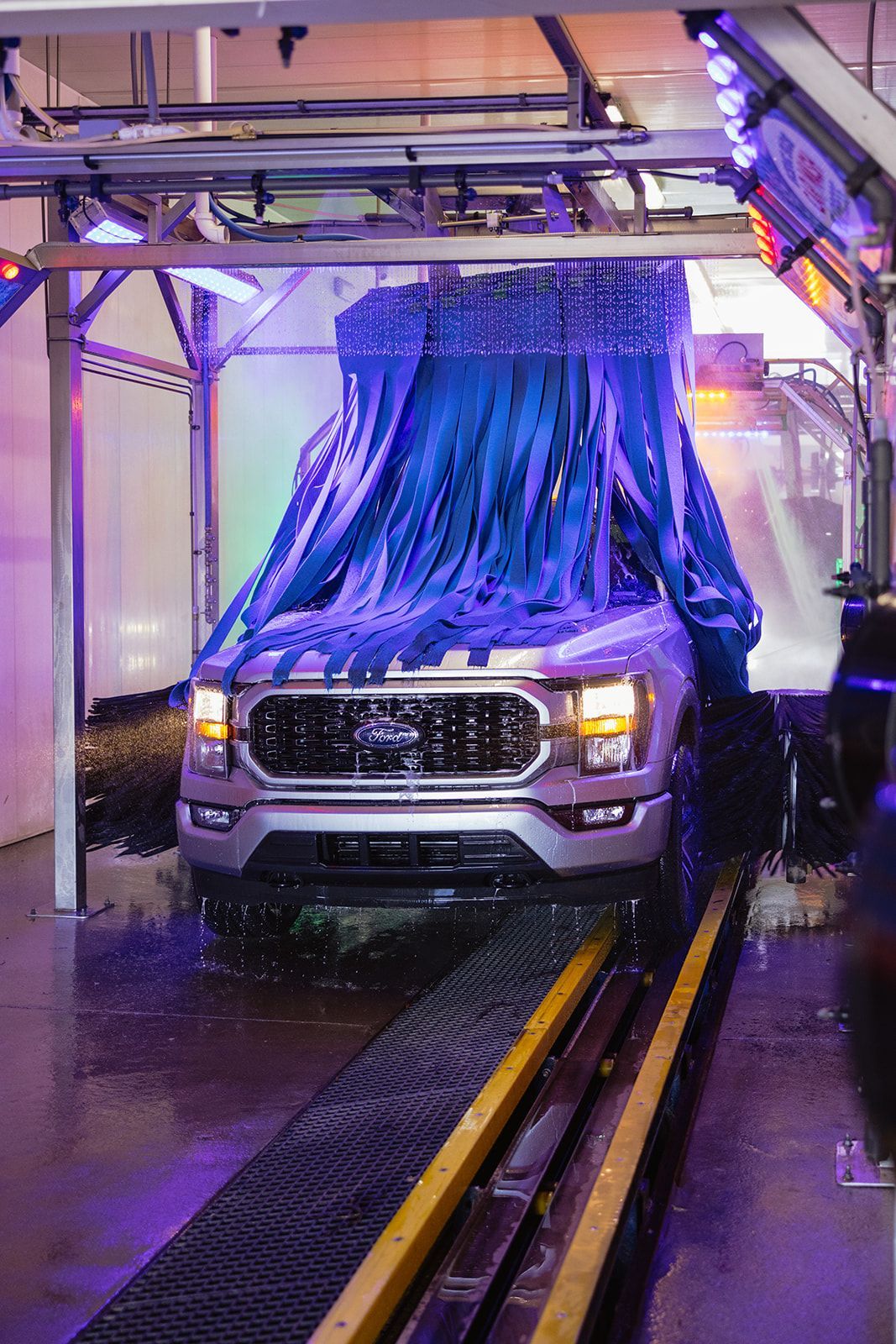 A truck is being washed in a car wash.