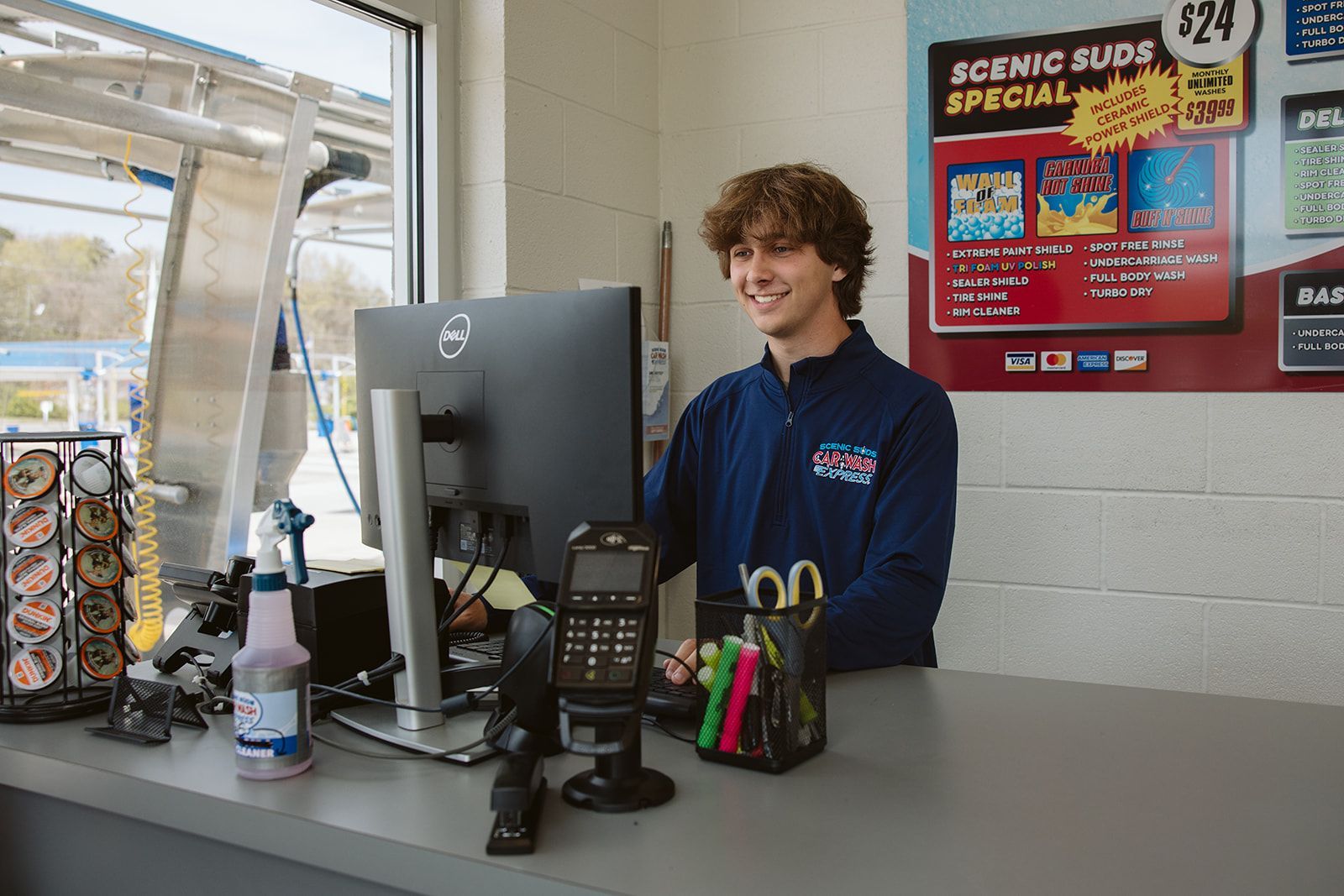 A man is sitting at a counter in front of a computer.