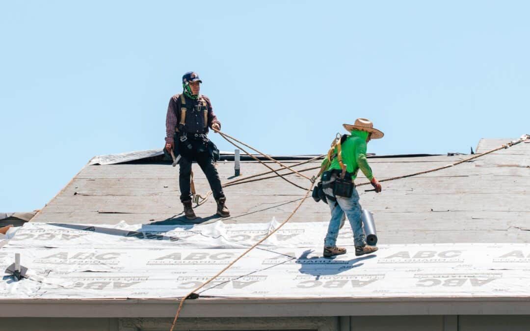 Two men are working on the roof of a building.