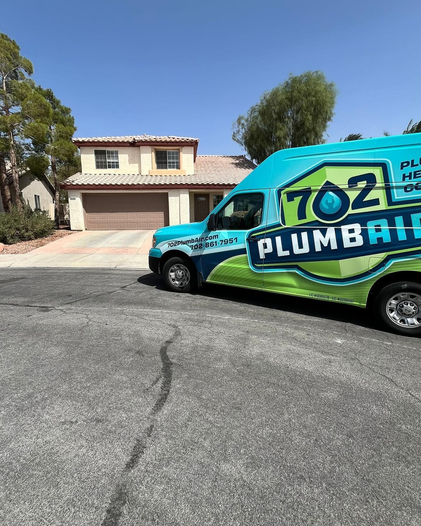 A plumbing truck is parked in front of a house.