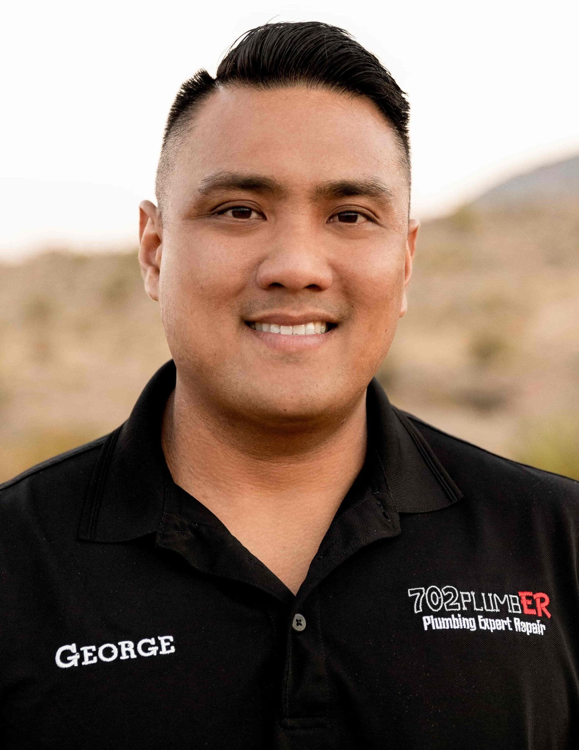 A man in a black shirt is smiling for the camera.