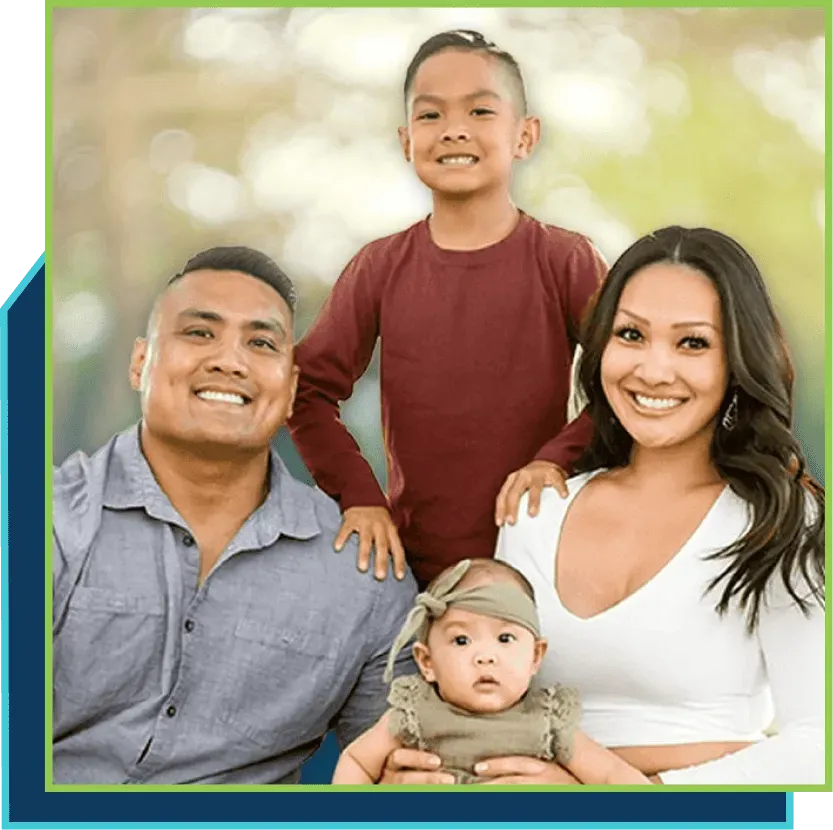 A family is posing for a picture together and smiling for the camera.