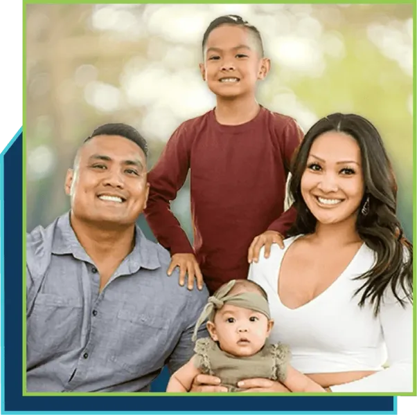 A family is posing for a picture together and smiling for the camera.