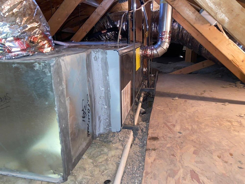 An air conditioner is sitting in the attic of a house.