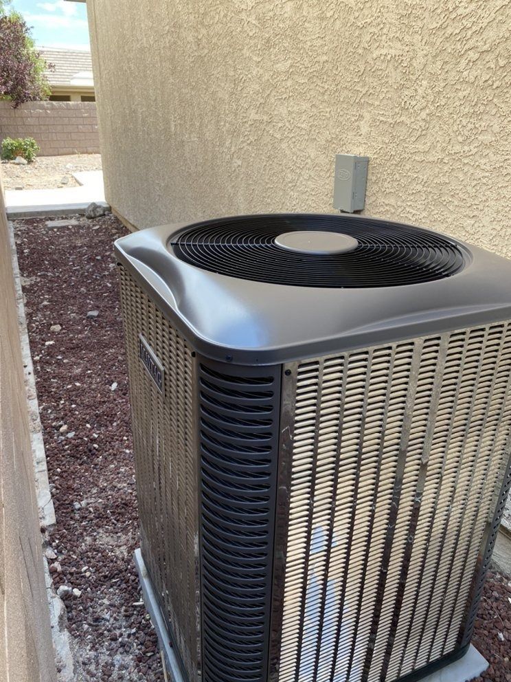 A large air conditioner is sitting on the side of a building.