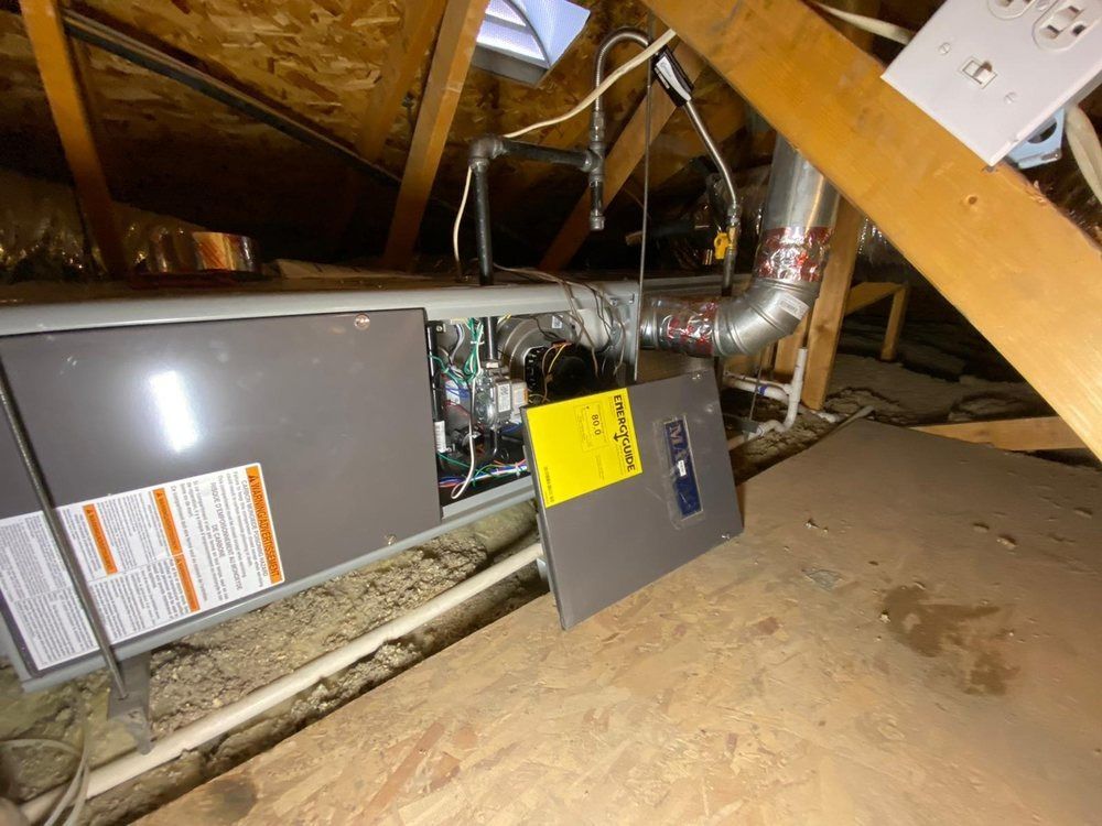 An air conditioner is sitting in the attic of a house.