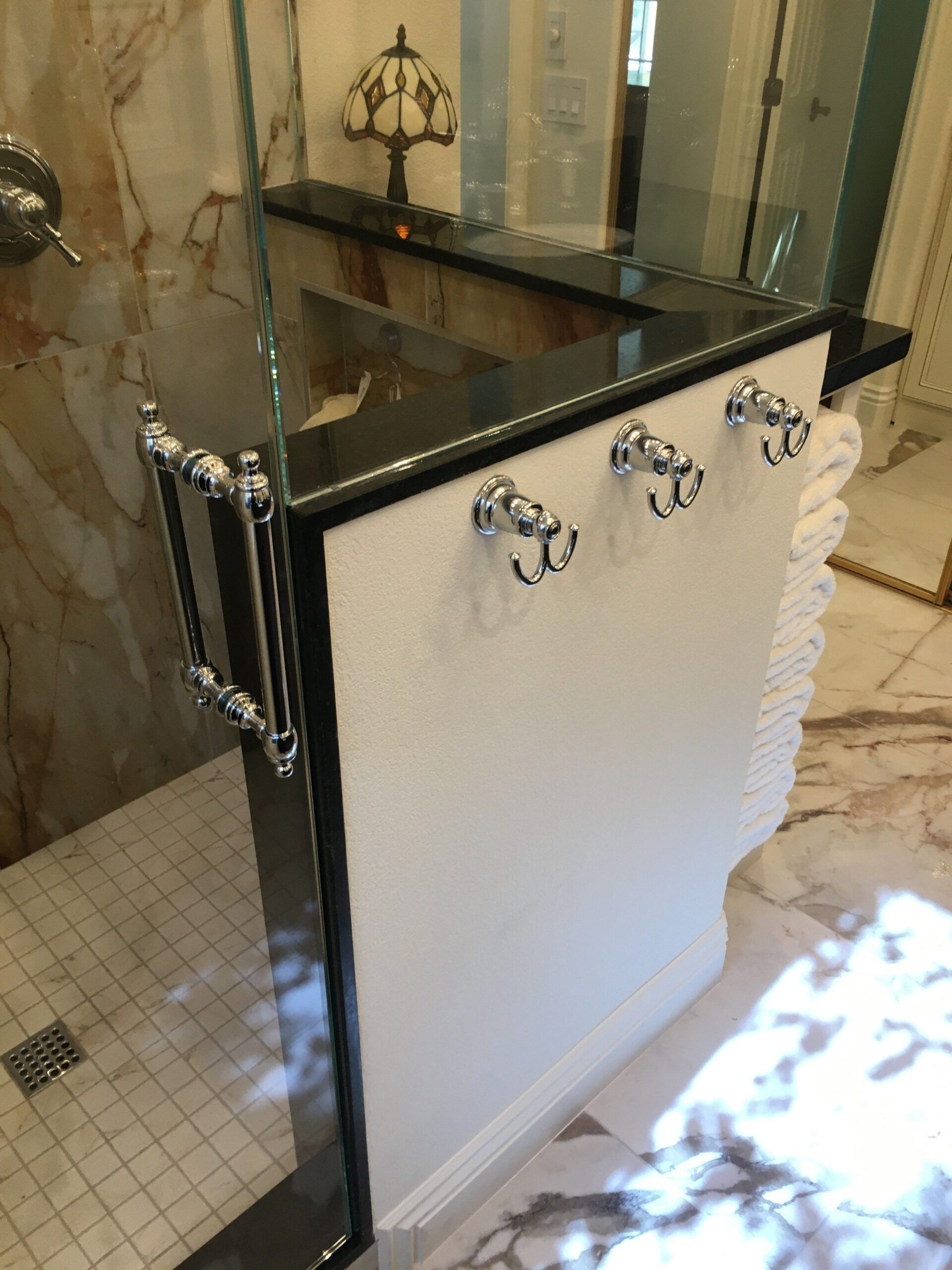 A bathroom with a walk in shower and a sink