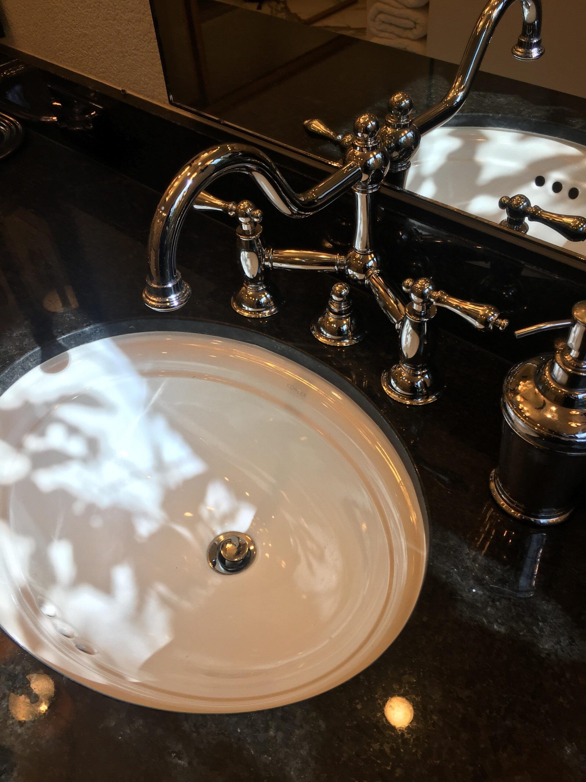 A bathroom sink with a soap dispenser and a mirror