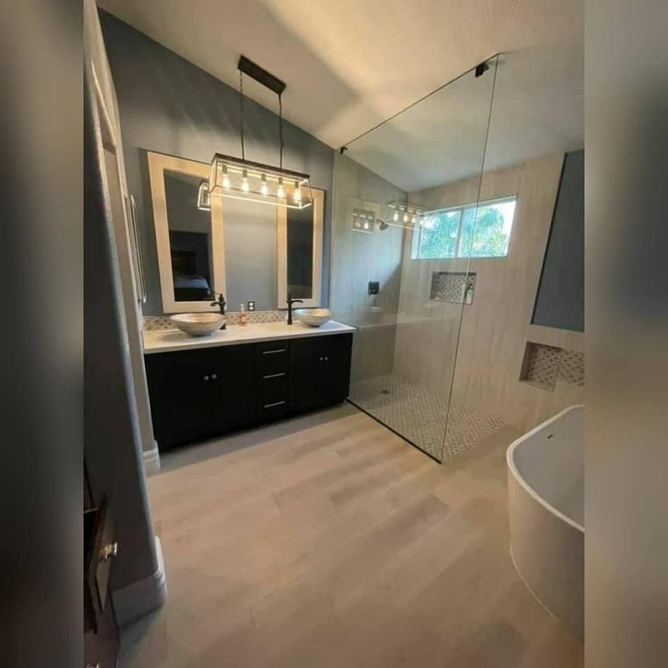 A bathroom with two sinks and a walk in shower.