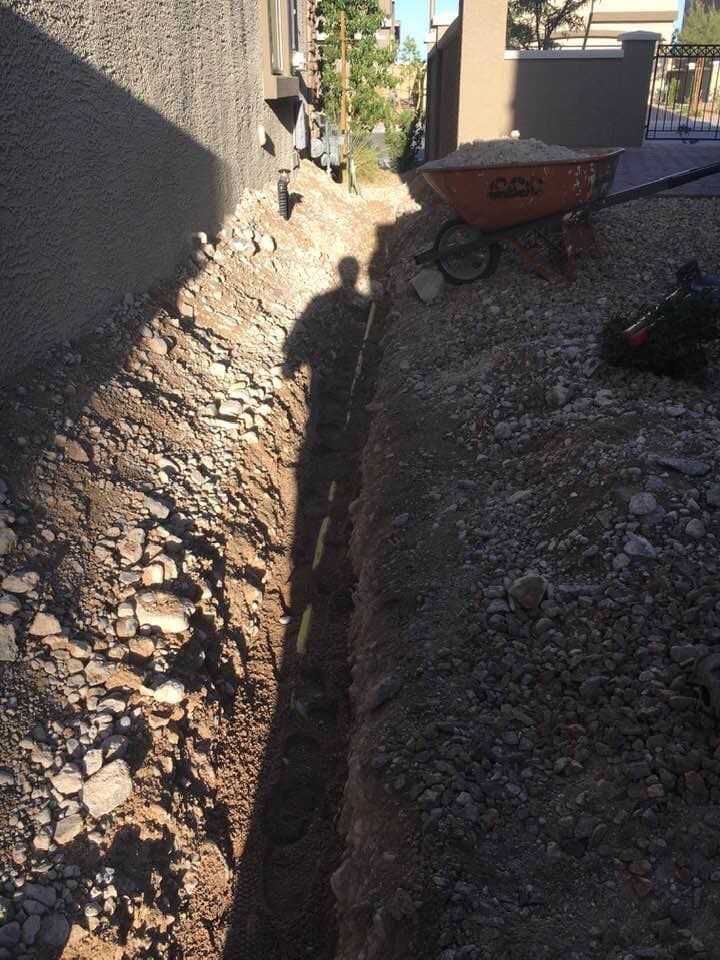A wheelbarrow is sitting on the side of a dirt road