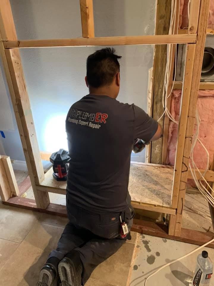 A man is kneeling down in a room while working on a project.
