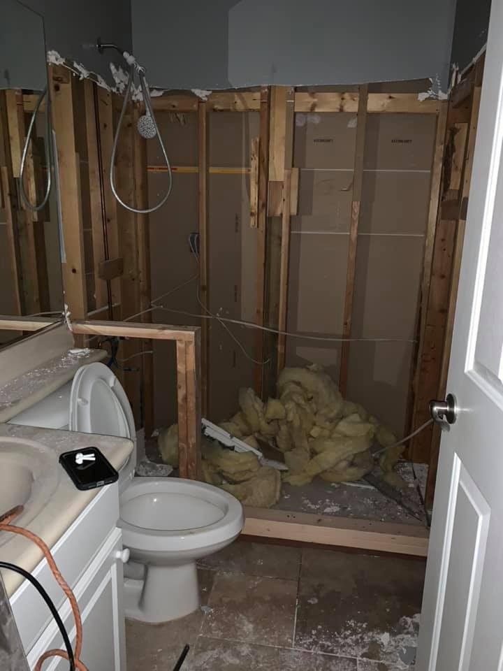 A bathroom with a toilet , sink and shower under construction.