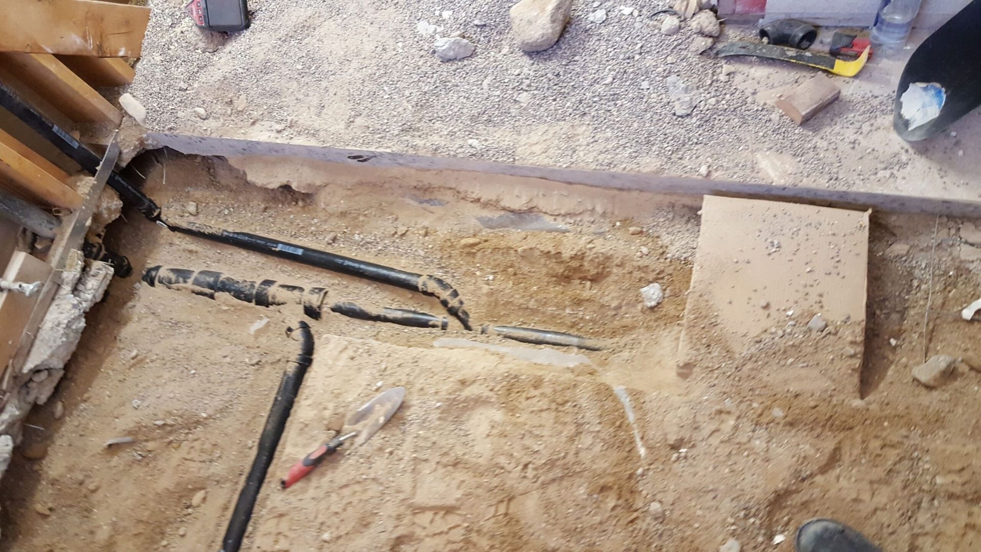 A bunch of wires are laying in the dirt on the ground.