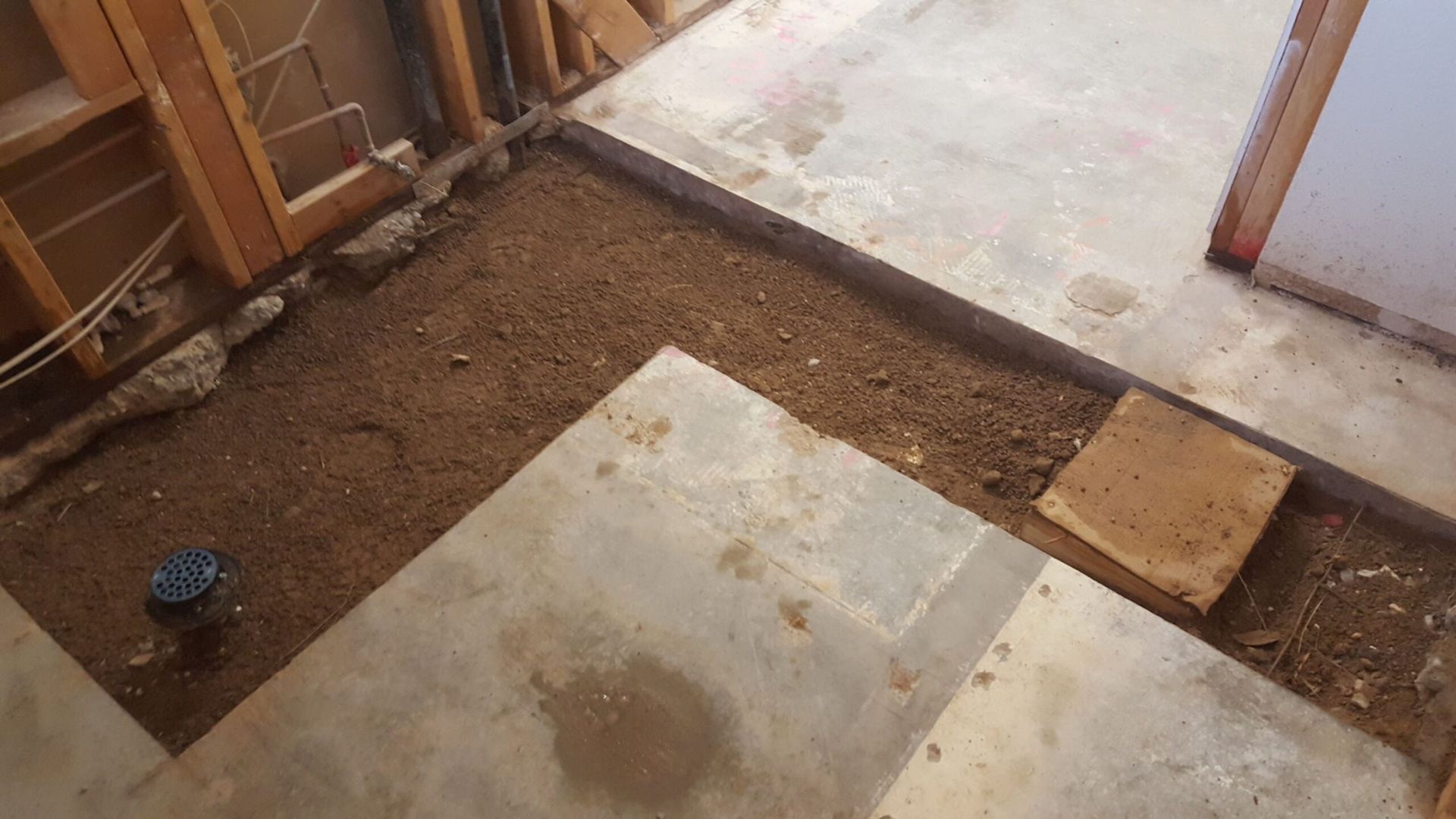 A room with a concrete floor and a wooden wall.