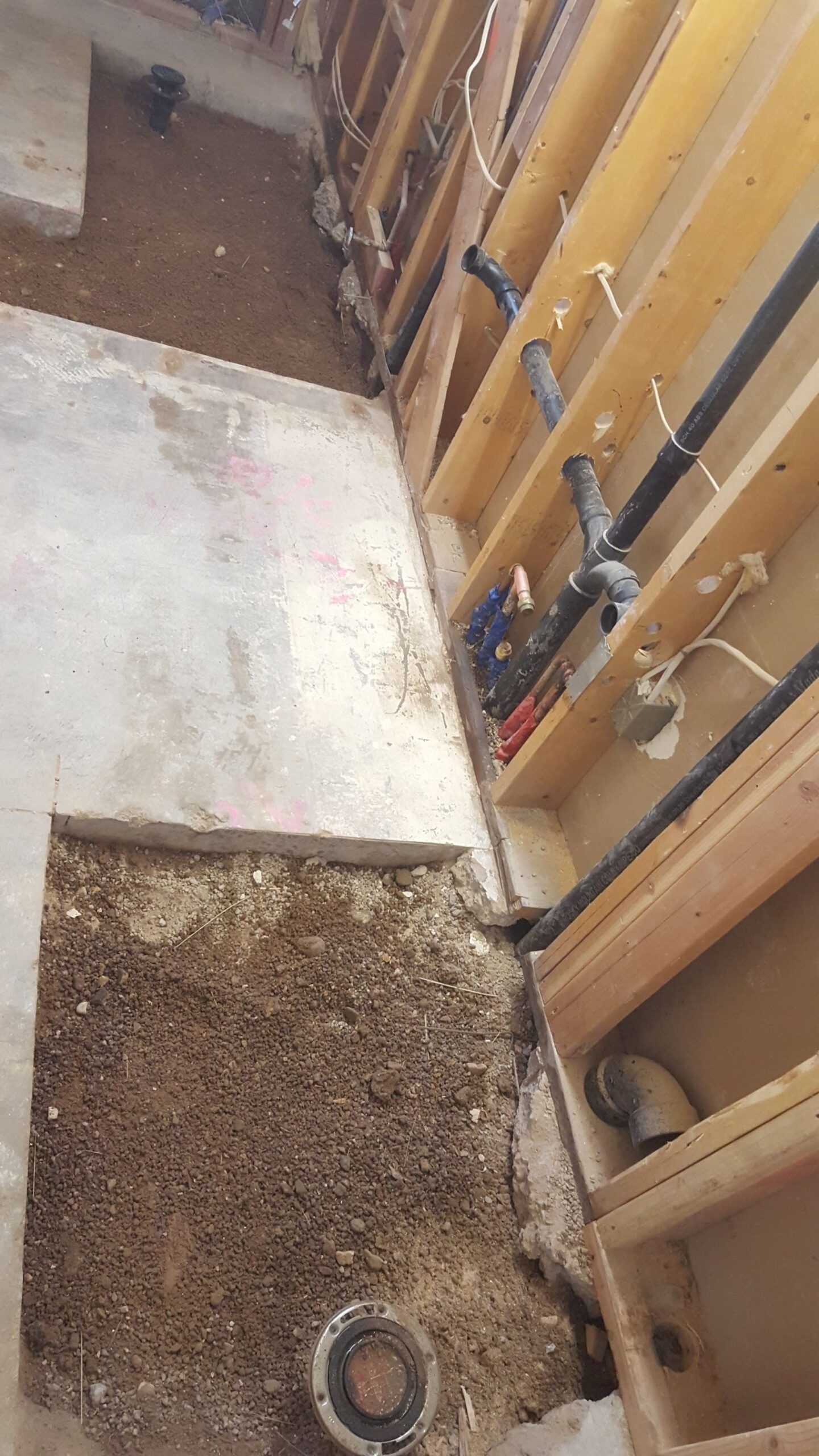 A room with a lot of pipes and a concrete floor.