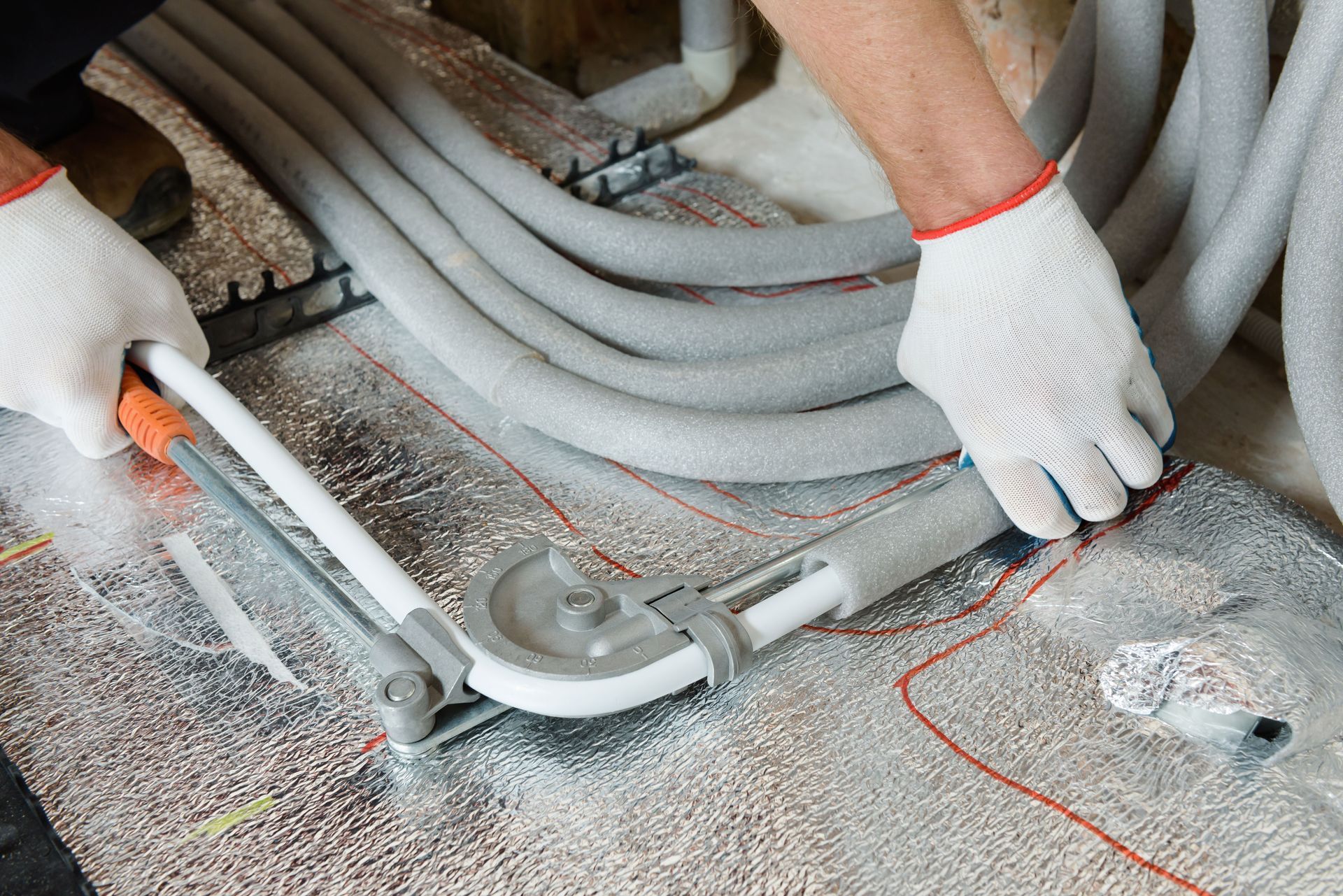 A person is cutting a pipe with a pipe cutter.