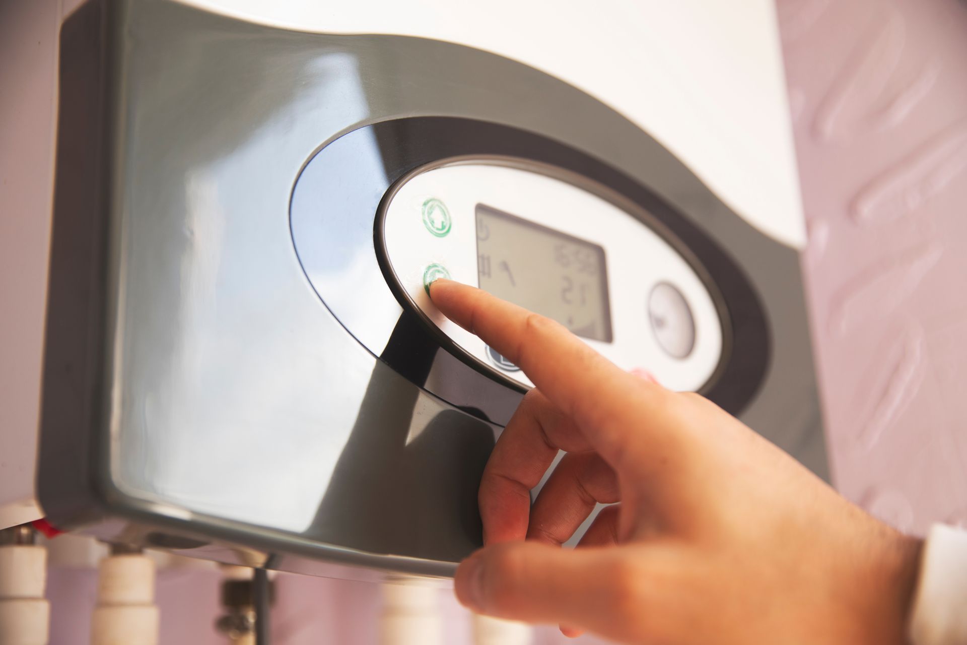 A person is pressing a button on a thermostat.