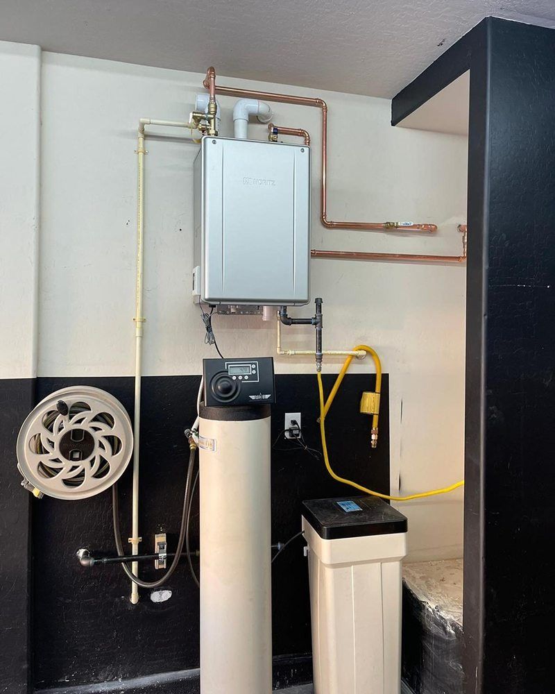 A room with a water heater and a fan on the wall