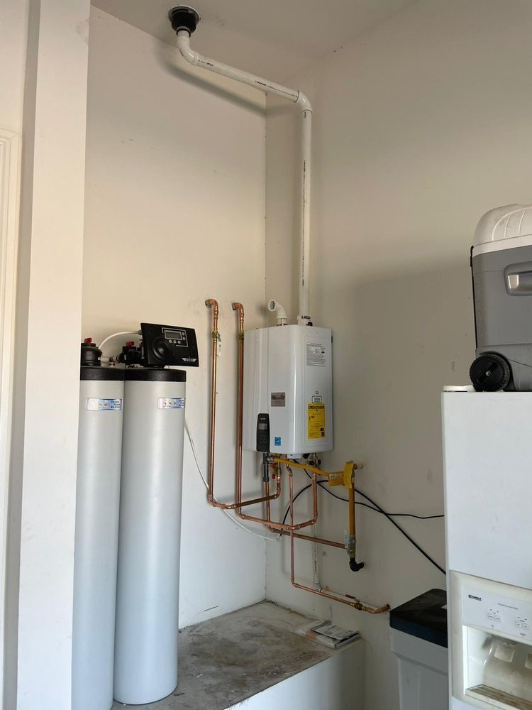 A room with a water heater and a washer and dryer.