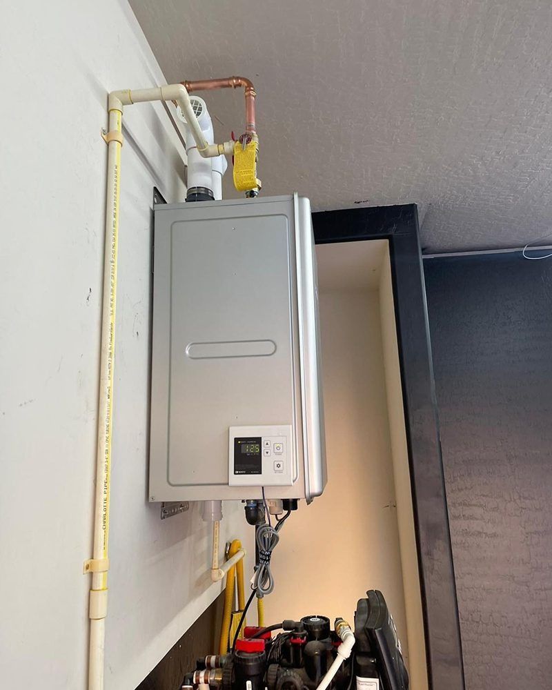 A gas heater is mounted to a wall with a yellow pipe attached to it