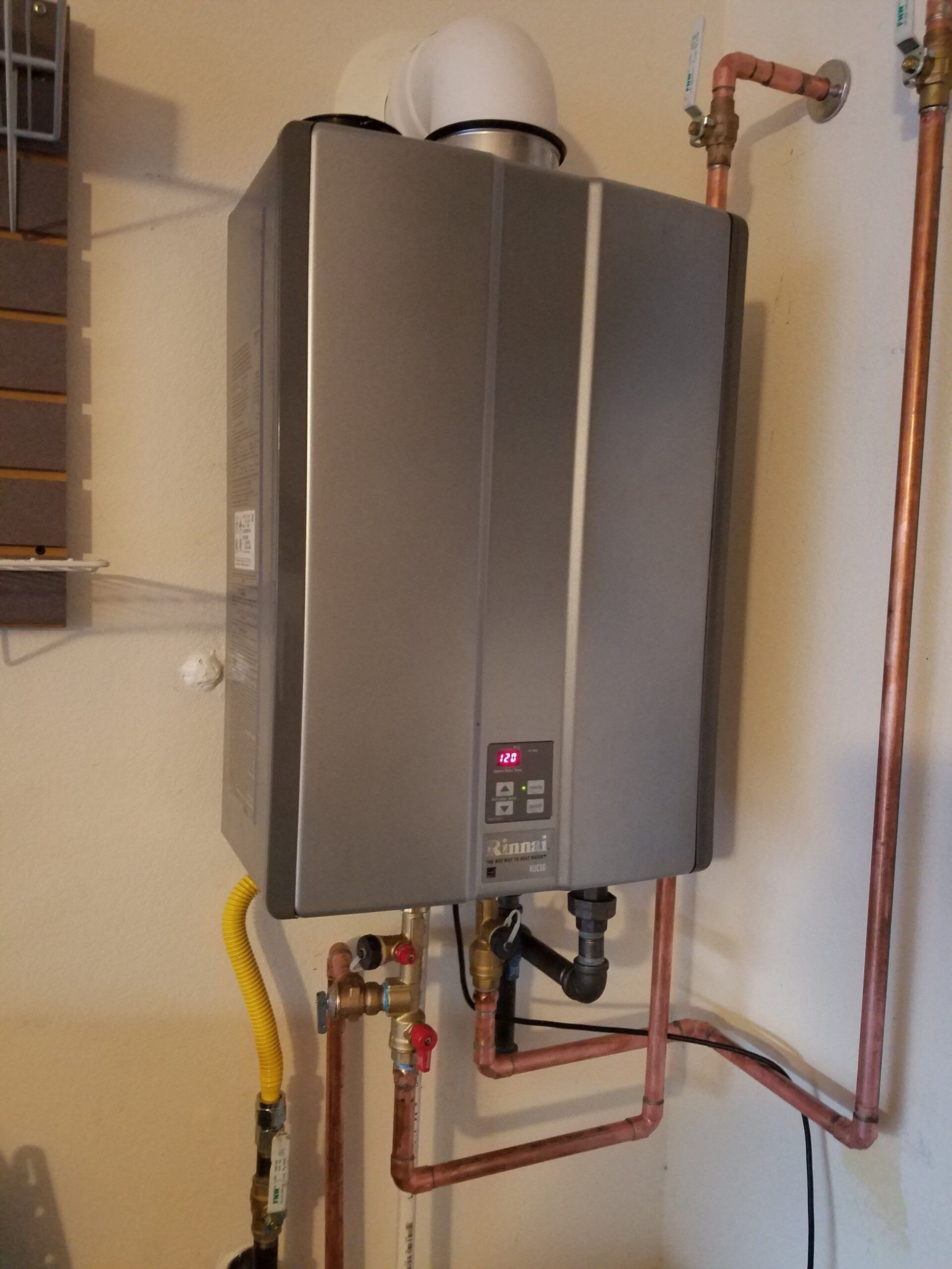 A water heater with copper pipes attached to it