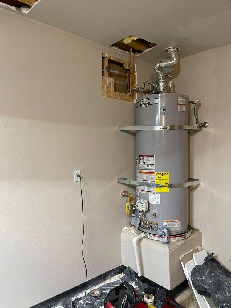 A water heater is sitting in a corner of a room.