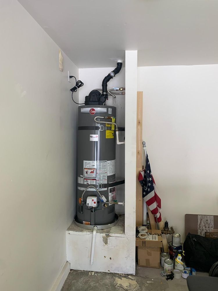 A water heater is sitting in a corner of a room.