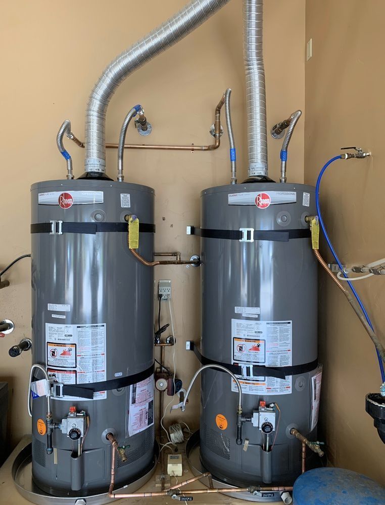 Two water heaters are sitting next to each other in a room.