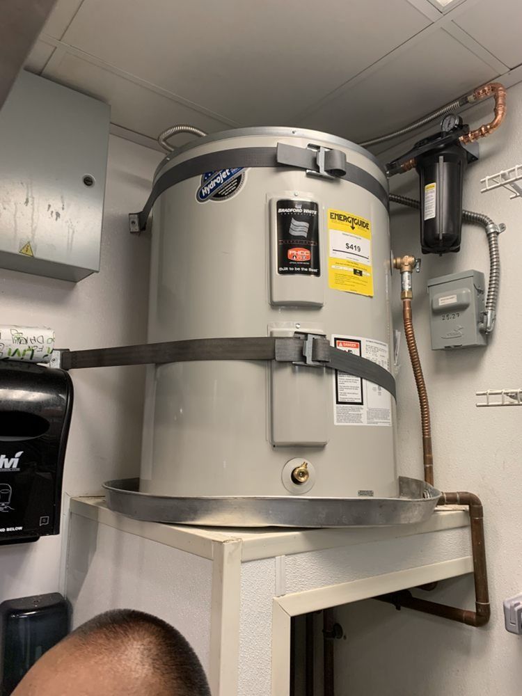 A large water heater is sitting on top of a counter in a bathroom.