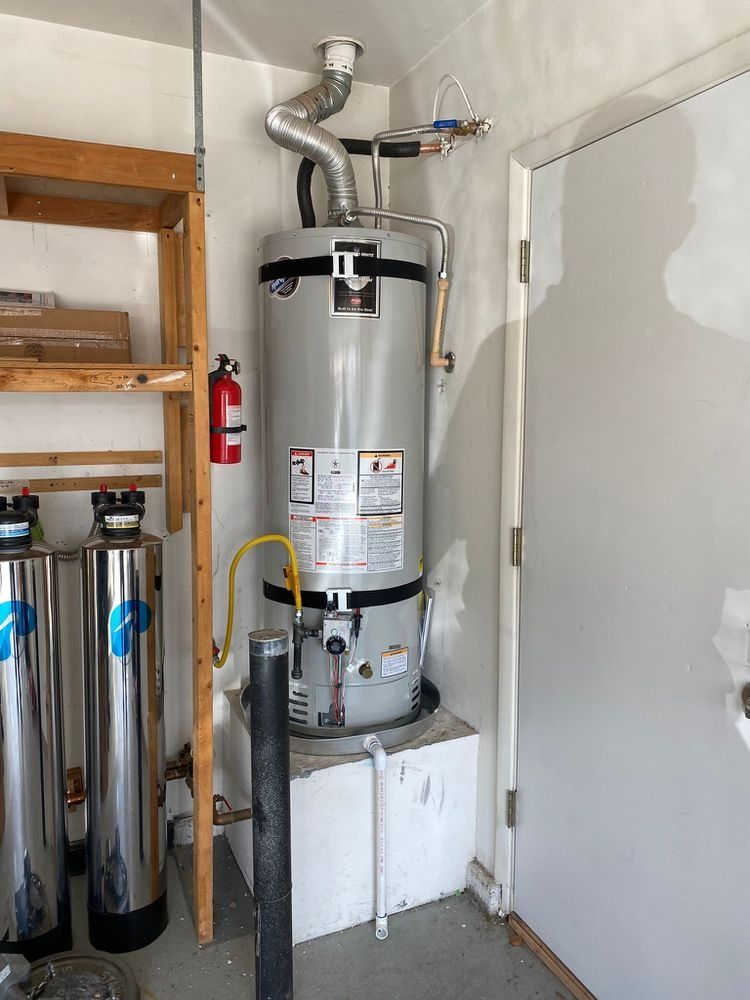 A water heater is sitting in a room next to a door.