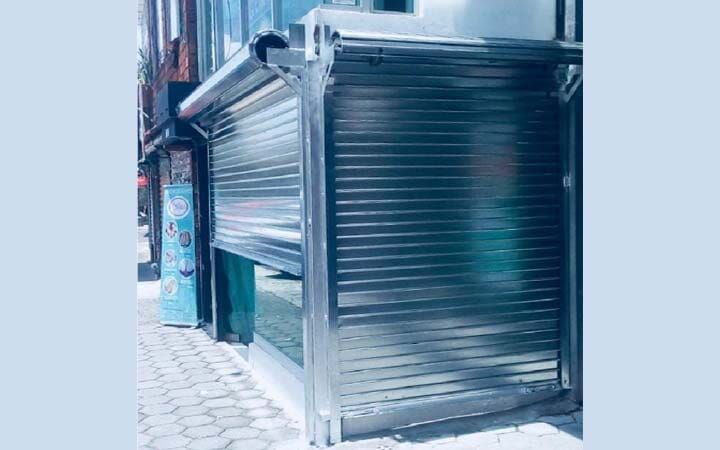 Una persiana enrollable de acero inoxidable en el lateral de un edificio.