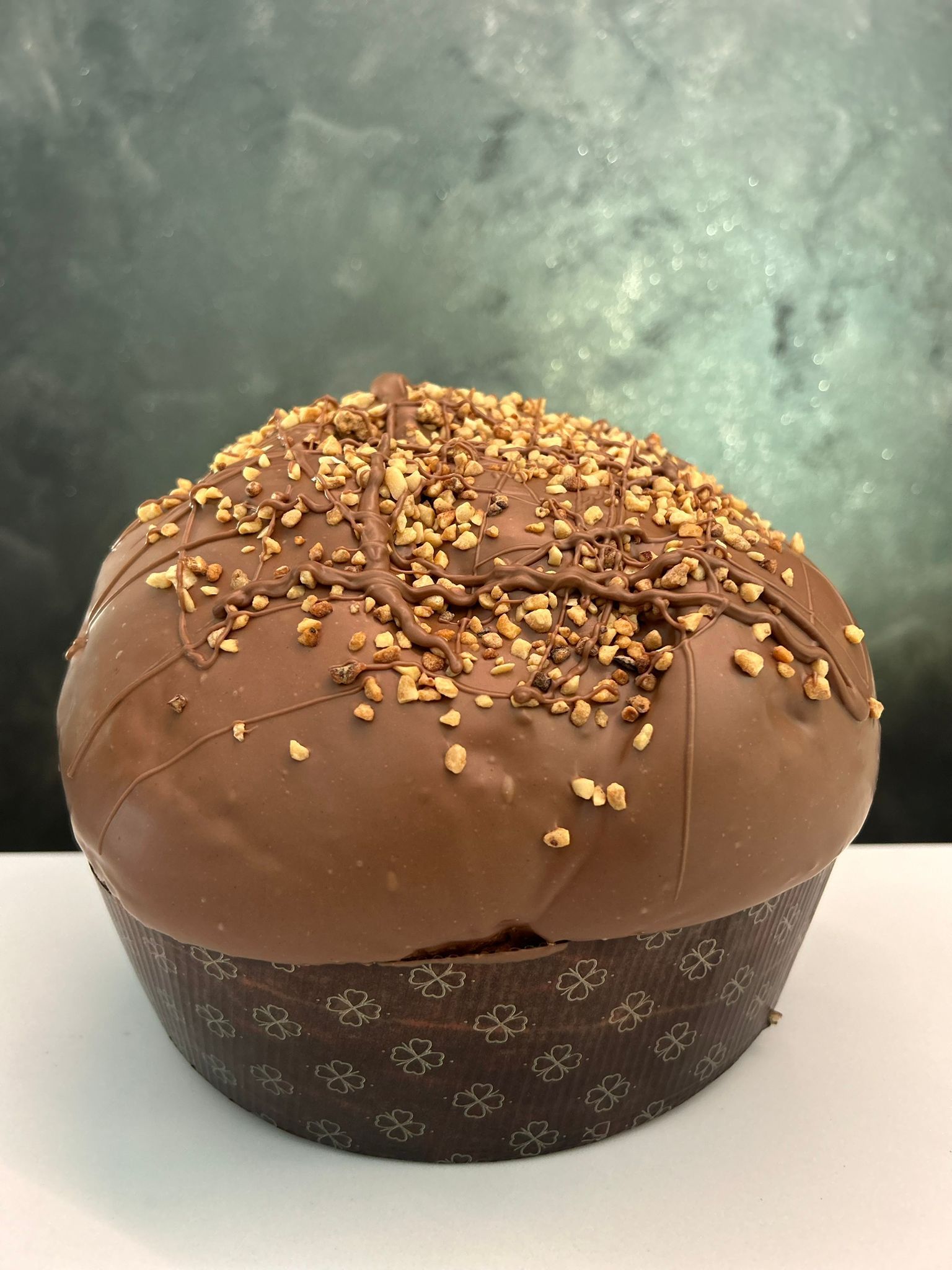 un panettone al cioccolato con sopra delle noci è appoggiata su un tavolo.