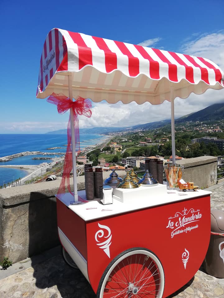 Un carretto dei gelati con una tenda a strisce rosse e bianche