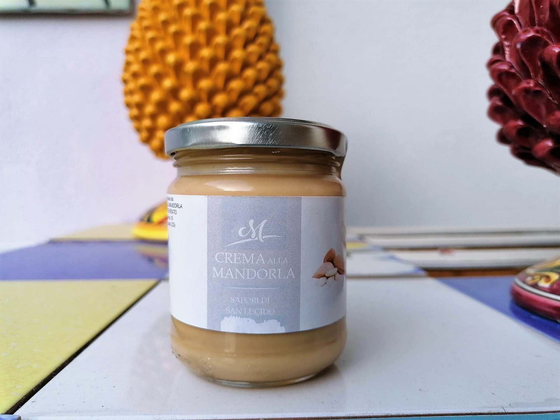 Un barattolo di crema di mandorle è appoggiato su un tavolo