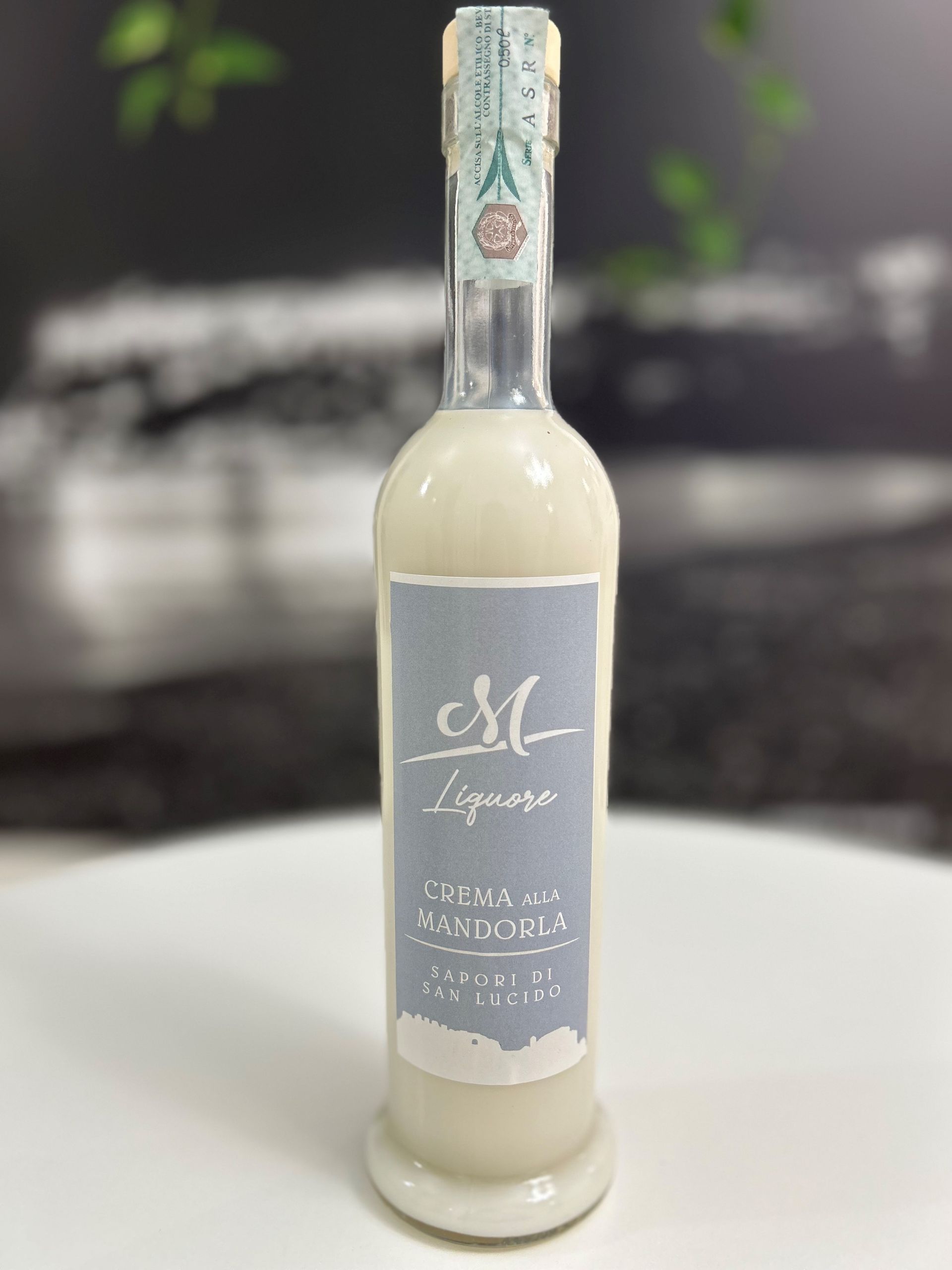 Una bottiglia di liquore è appoggiata su un tavolo bianco.