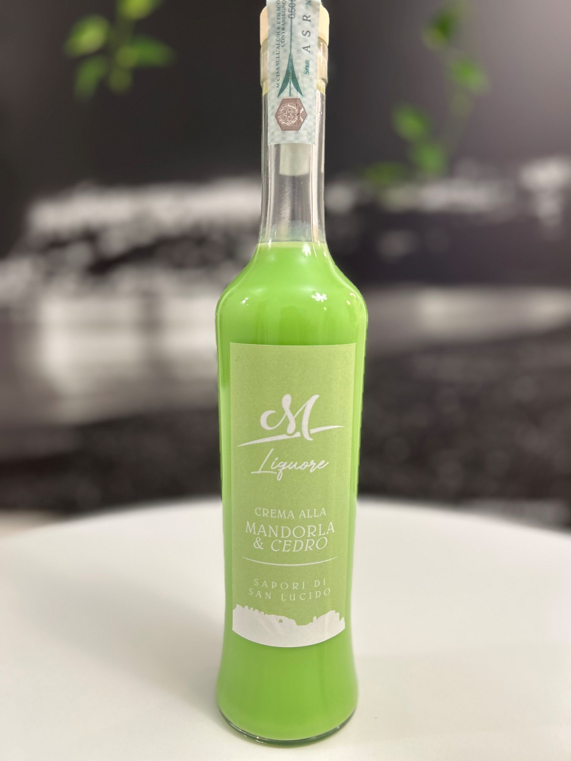 Una bottiglia verde di liquore è appoggiata su un tavolo.