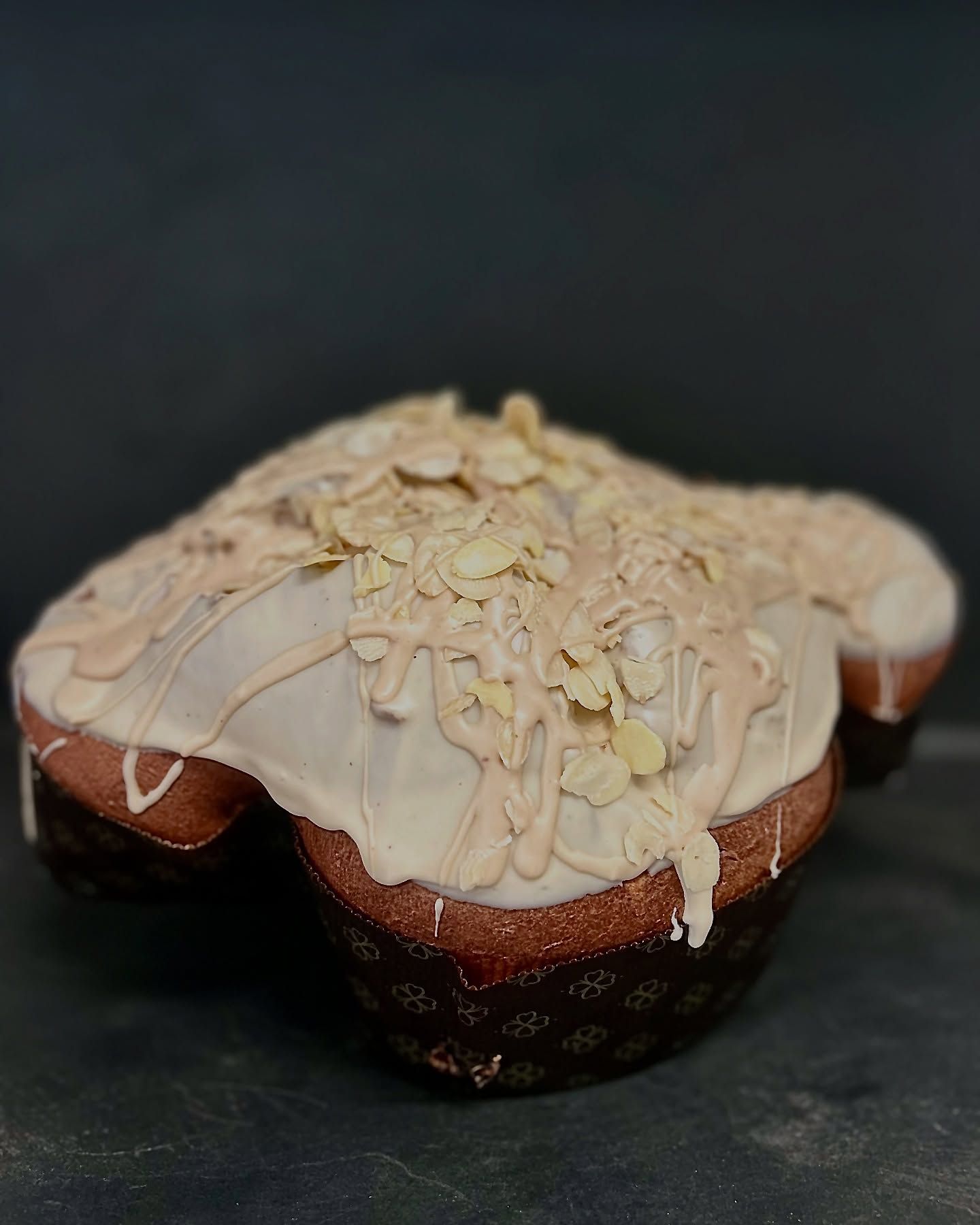 colomba artigianale con mandorle sopra, su un tavolo.