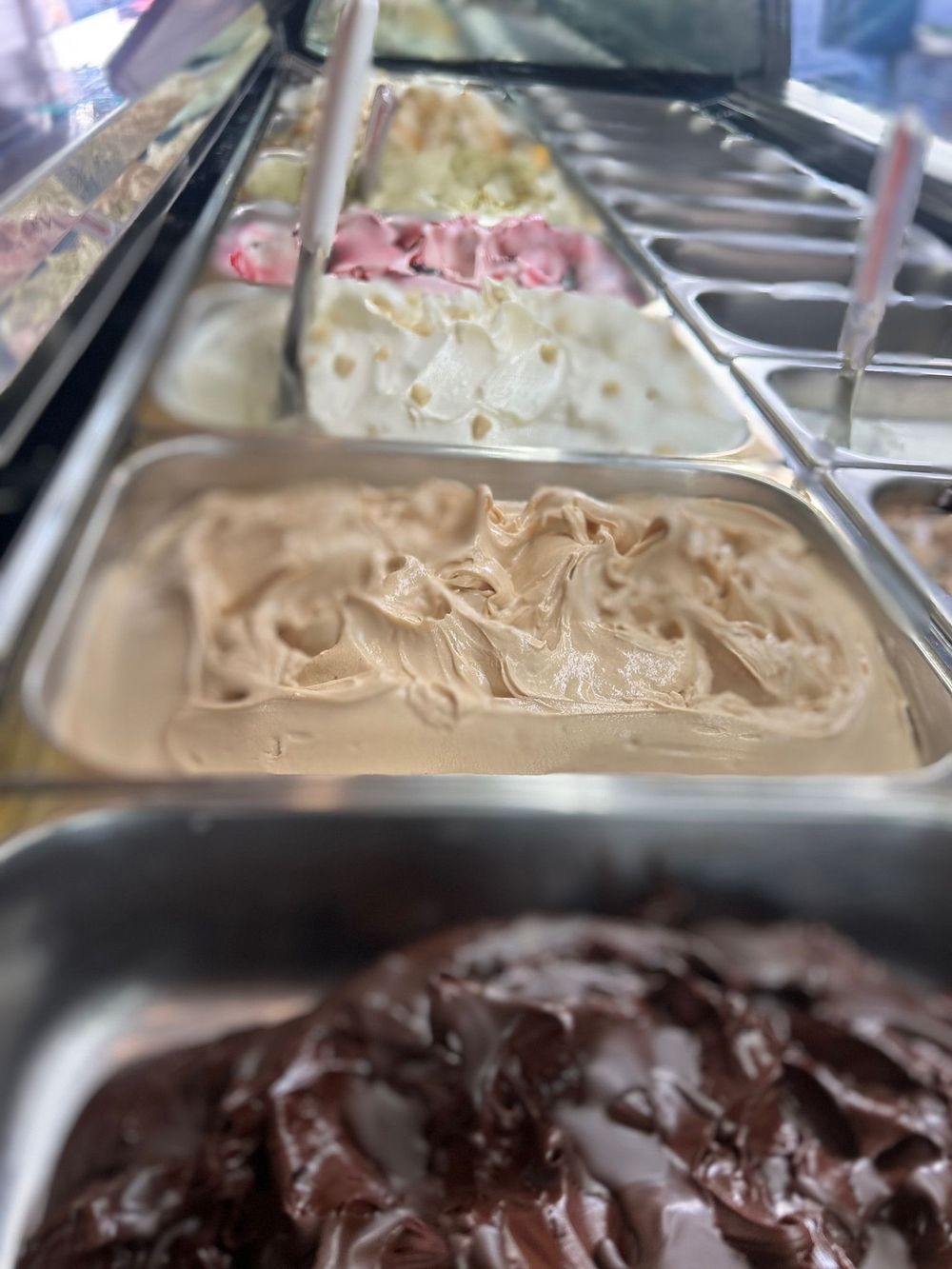 Una vetrina piena di tanti gusti diversi di gelato.