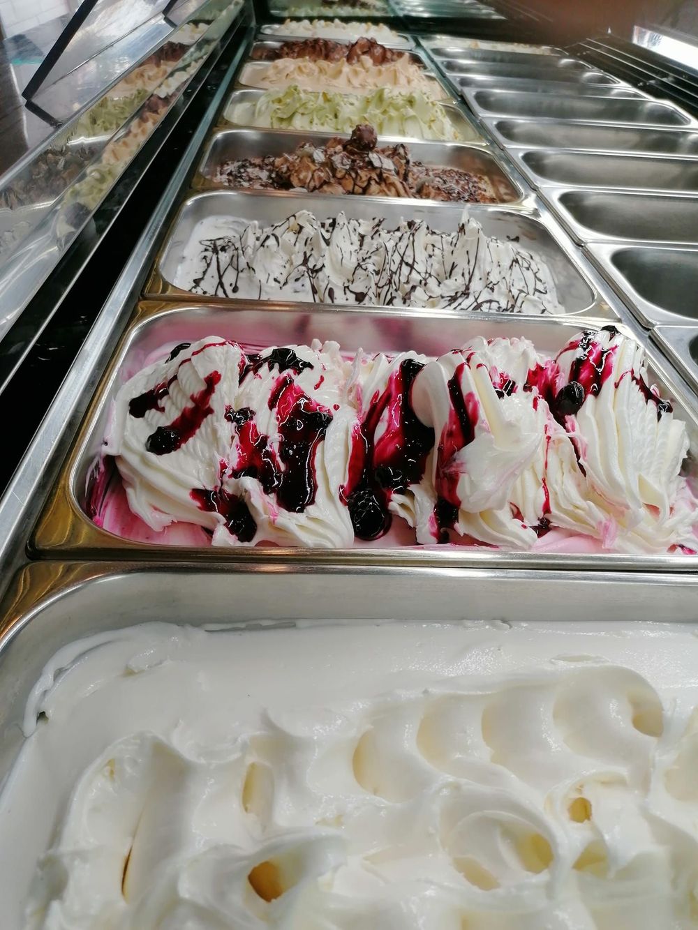 Ci sono molti gusti diversi di gelato nelle vaschette.