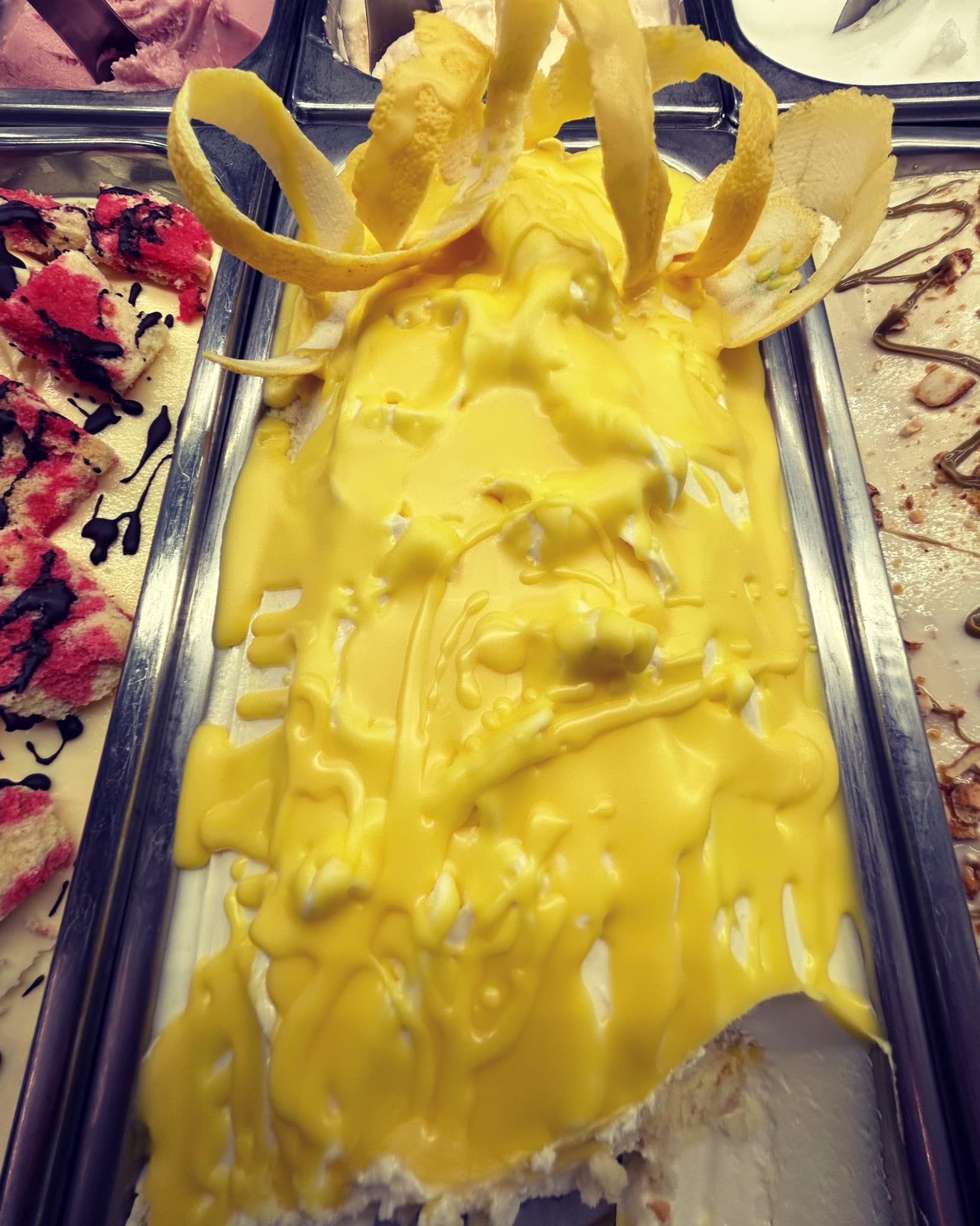 Una vaschetta di gelato con una salsa gialla sopra.