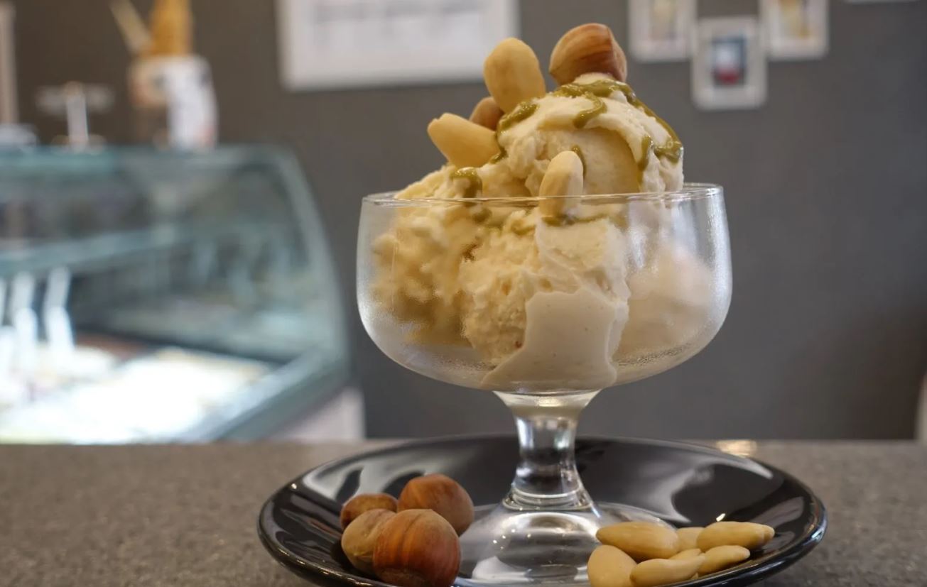 Una ciotola di gelato con sopra delle noci