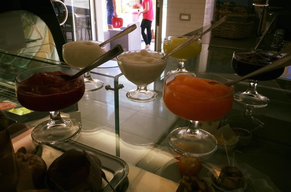 Una mostra di diversi gusti di gelato con cucchiaini al loro interno