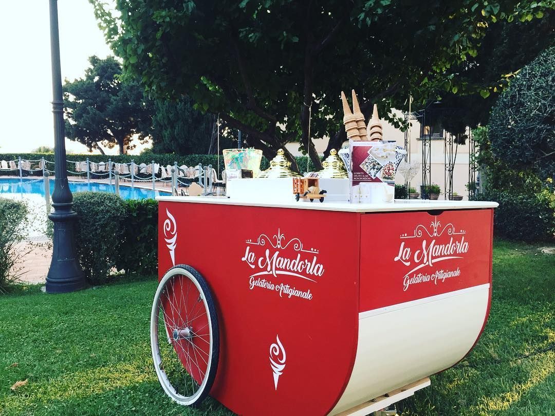 Un carretto dei gelati rosso e bianco è parcheggiato sull'erba