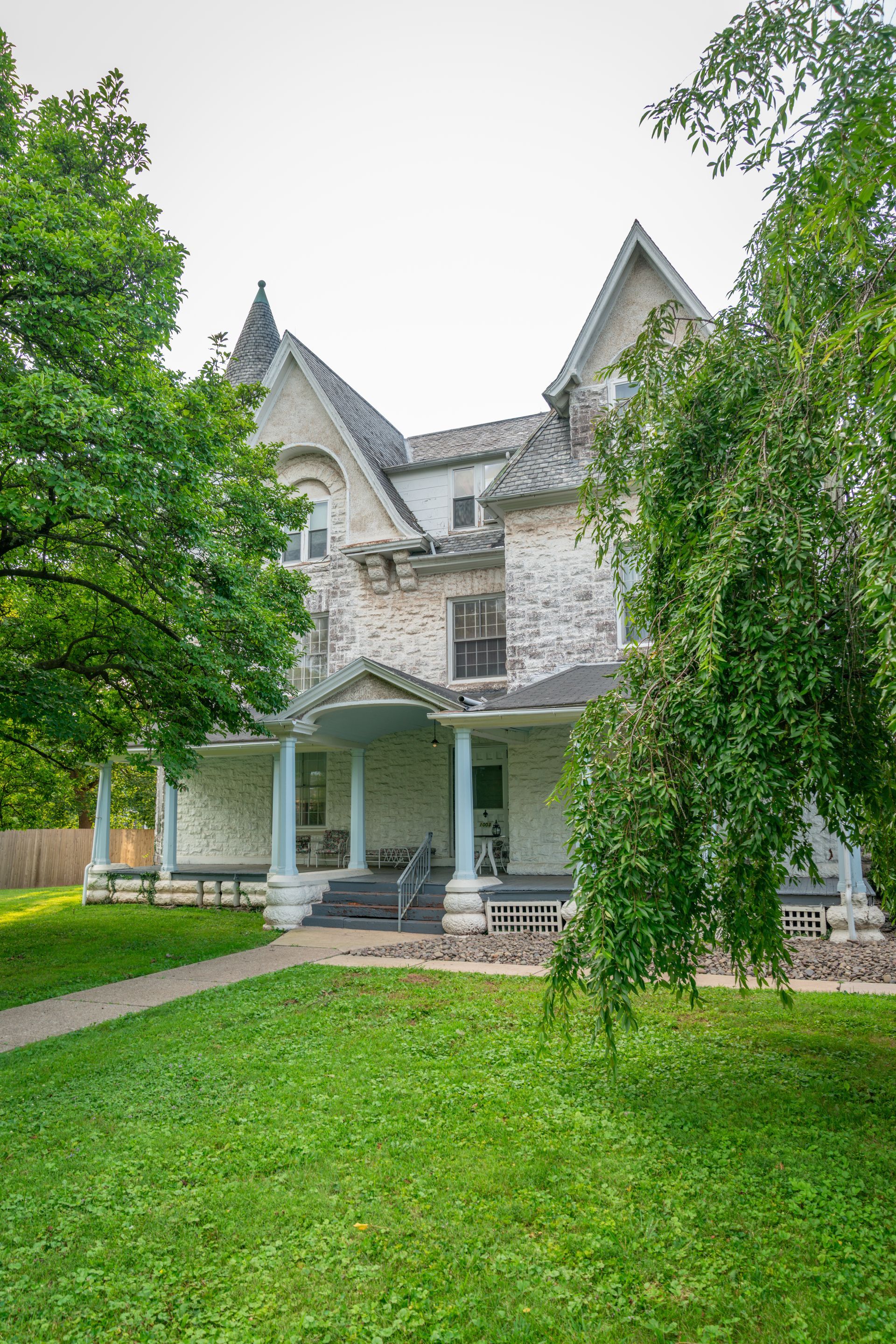 Photo of the front of a building, with columns leading up to the porch