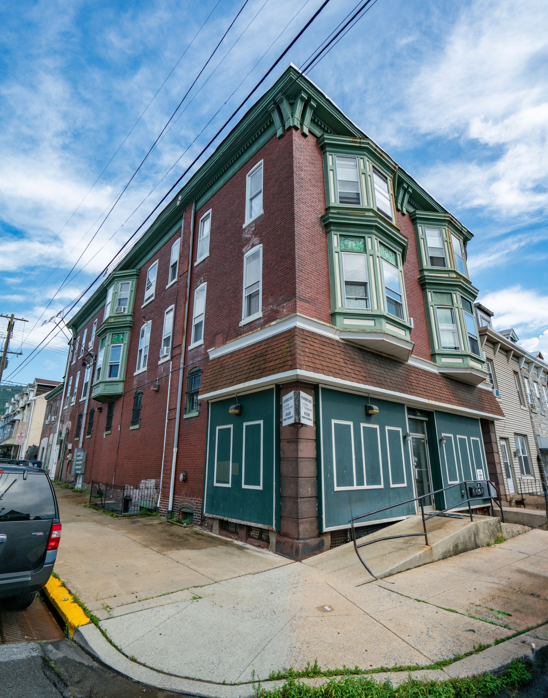 Photo of a building at a corner, showing the front and side of a 3 story building