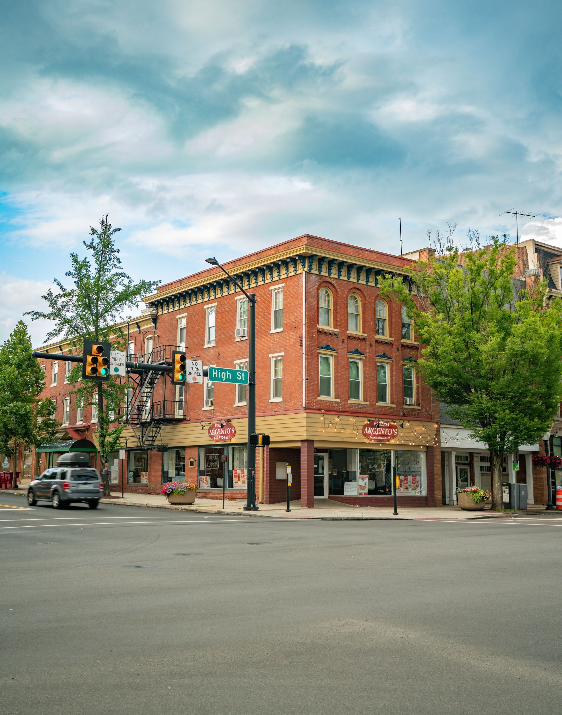 Photo of a 3 story building, seen from across the street, at the corner of it's block